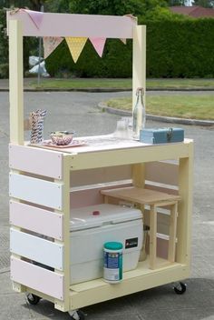 an outdoor ice cream cart is painted pink and white