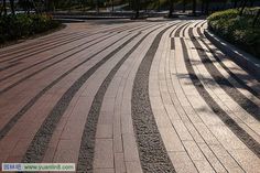 an empty street with curved brick pavement and trees