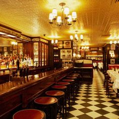 an empty restaurant with checkered flooring and chandeliers