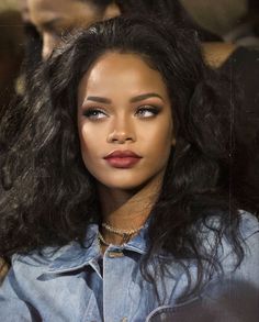 a close up of a person wearing a denim shirt with long hair and red lipstick