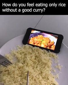 a white plate topped with rice next to a fork and cell phone on top of it