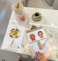 a person is sitting at a table holding a clipboard and looking at some items on it