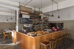 a restaurant with lots of counter space and hanging lights above the bar, along with wooden stools