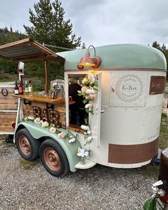 an old fashioned food truck is decorated with flowers