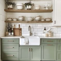 a kitchen with green cabinets and white subway backsplashes is pictured in this image