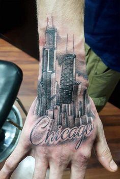 a man's hand with the chicago skyline tattooed on it