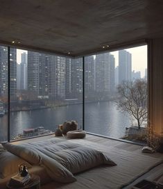 a bedroom with a large window overlooking the water and cityscape in the background