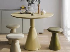 a table with two stools and a potted plant