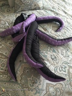 three purple and black pillows laying on top of a bed