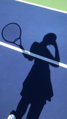 the shadow of a person holding a tennis racket