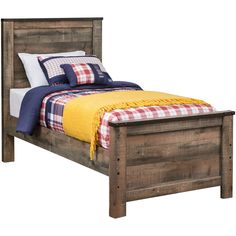 a bed with a plaid blanket on top of it next to a pillow and pillows