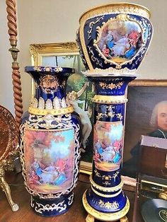 three vases sitting on top of a wooden table next to pictures and other items