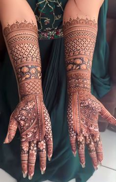 a woman's hands with hennap on her arm and hand, showing the intricate