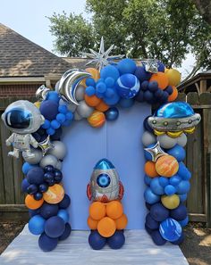 an arch made out of balloons and other items in the shape of rockets, planets, and stars