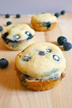 three blueberry muffins on a wooden table