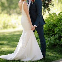 a bride and groom holding hands under an umbrella