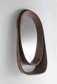 a mirror mounted to the side of a wall next to a wooden shelf with a circular mirror on it