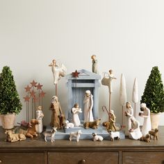 an assortment of christmas figurines on top of a dresser