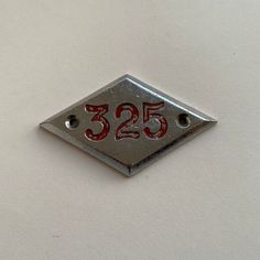 a metal sign with the number 350 on it's side and two holes at the bottom