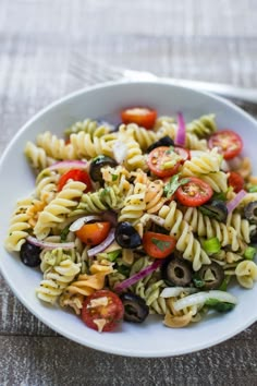 a white bowl filled with pasta salad on top of a table