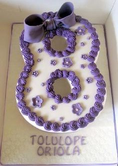 a cake with purple icing and bows on it in a box for someone's 30th birthday