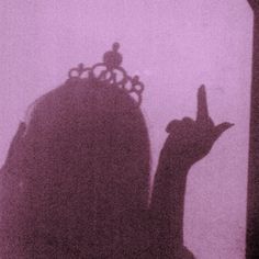 the silhouette of a bird with a crown on its head is shown against a foggy background