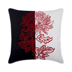 a black and white pillow with red flowers on the side, both in contrasting colors