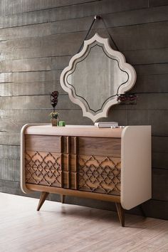 a dresser with a mirror on top of it next to a wooden floor and wall