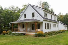 a white house sitting on top of a lush green field