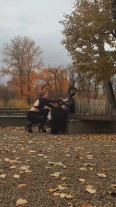 two people are sitting on a bench in the park and one is holding onto another person's leg