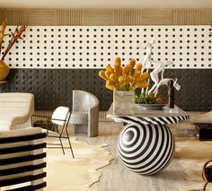 a living room filled with lots of furniture next to a wall covered in polka dots