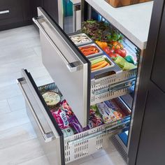 an open refrigerator filled with lots of food in a kitchen next to a counter top