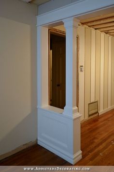 an empty room with wooden floors and white columns in the corner between two walls that have been stripped off