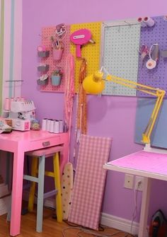 a pink desk and chair in a child's room with pegboard on the wall