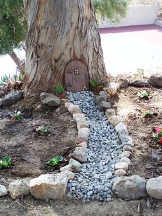 a rock path leading to a tree with a door