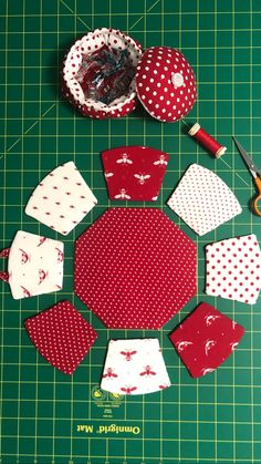 several pieces of fabric laid out on a cutting board with scissors and sewing supplies around them