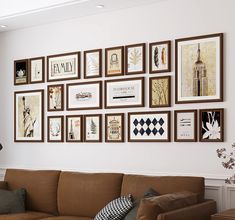 a living room filled with lots of framed pictures on the wall above a brown couch