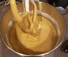 a metal bowl filled with batter and an electric mixer