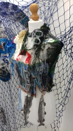 a mannequin is covered in plastic and other items that are sitting on top of a net