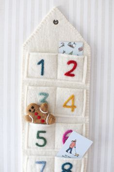 a teddy bear sitting on top of a felt board that has numbers and a teddy bear in it