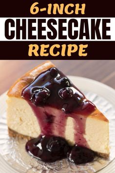 a slice of cheesecake on a plate with blueberries and sauce in the middle