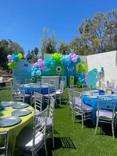 tables and chairs are set up in front of an outside wall with balloons on it