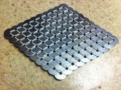 a close up of a metal object on a counter top with holes in the middle