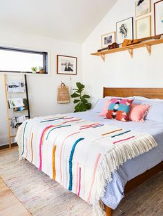 a bed with colorful blankets and pillows in a bedroom