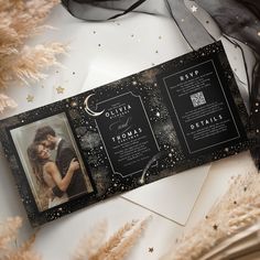 a black and gold wedding card with an image of a couple on the cover, surrounded by golden stars