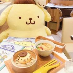 a stuffed animal sitting on top of a wooden tray next to a bowl of food