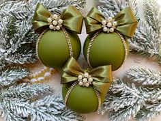 two green christmas balls with bows on them