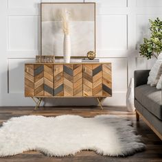 a living room with a couch, chair and rug on the floor in front of a mirror