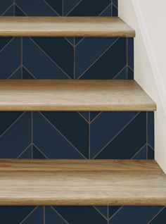 wooden steps with blue tiles on the bottom and bottom, leading up to an upstairs stairwell