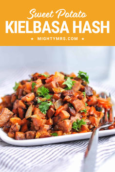 sweet potato kielbasa hash on a white plate with a fork and spoon next to it